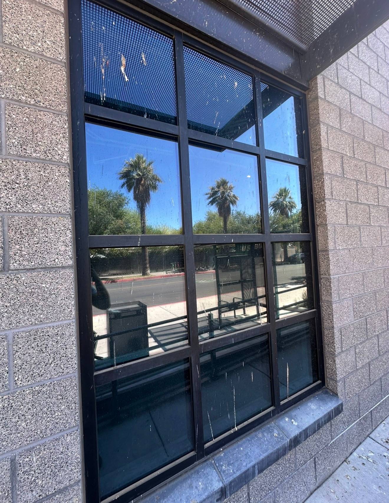 A storefront window before cleaning, spotted with dried spatter